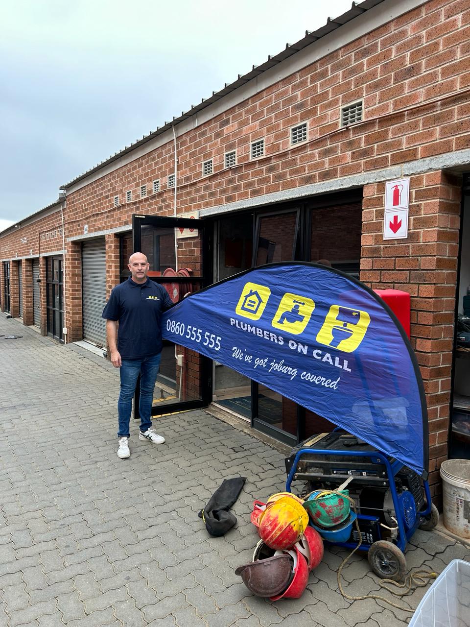 Plumbers on call signage with owner next to it